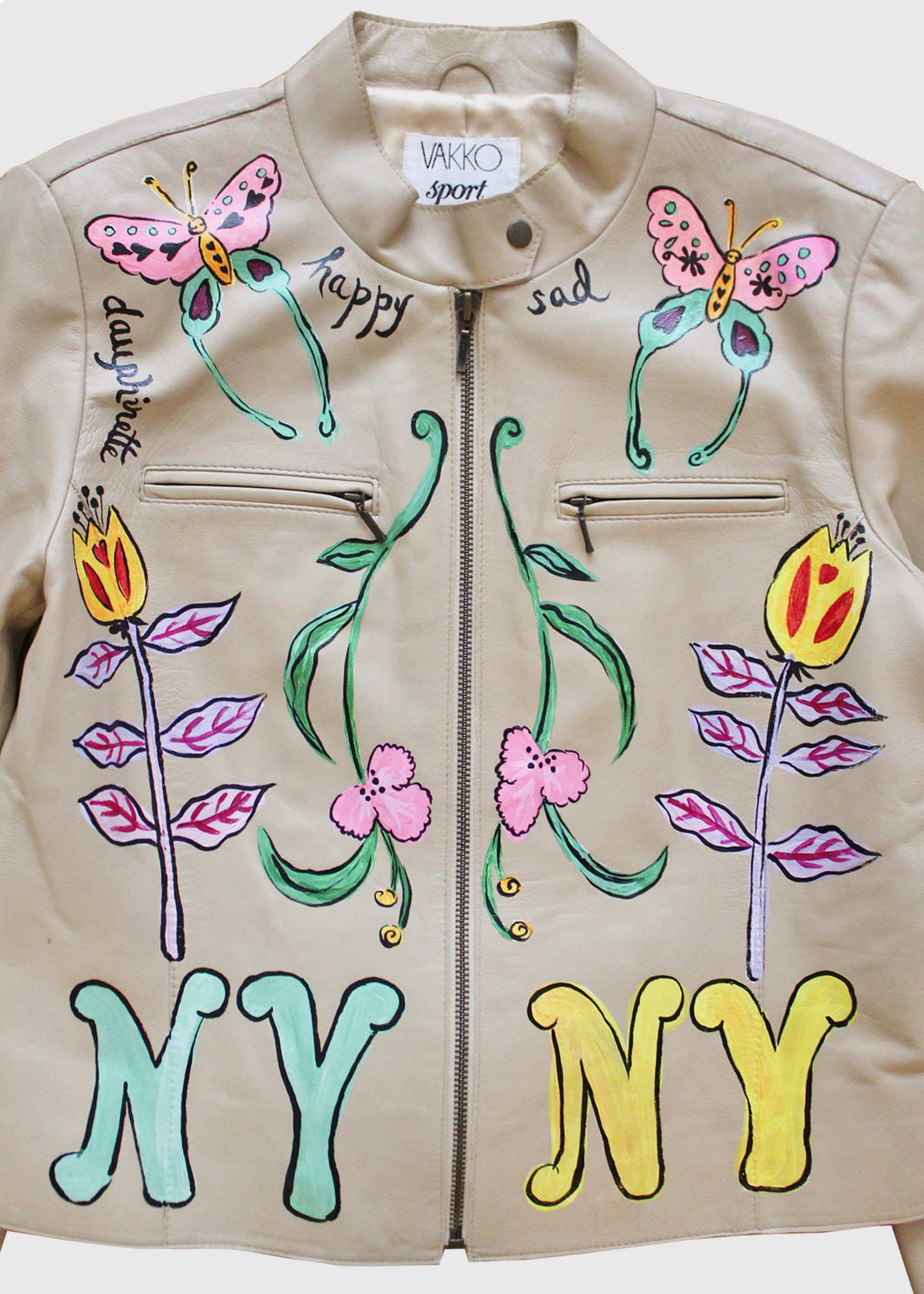a detail image of the Hand-painted 1980s leather jacket featuring an elaborate amalgamation of colorful butterflies, alien flowers, the words "happy" and "sad", and one mint green and one yellow "NY" painted on either side of the jackets center front zipper.