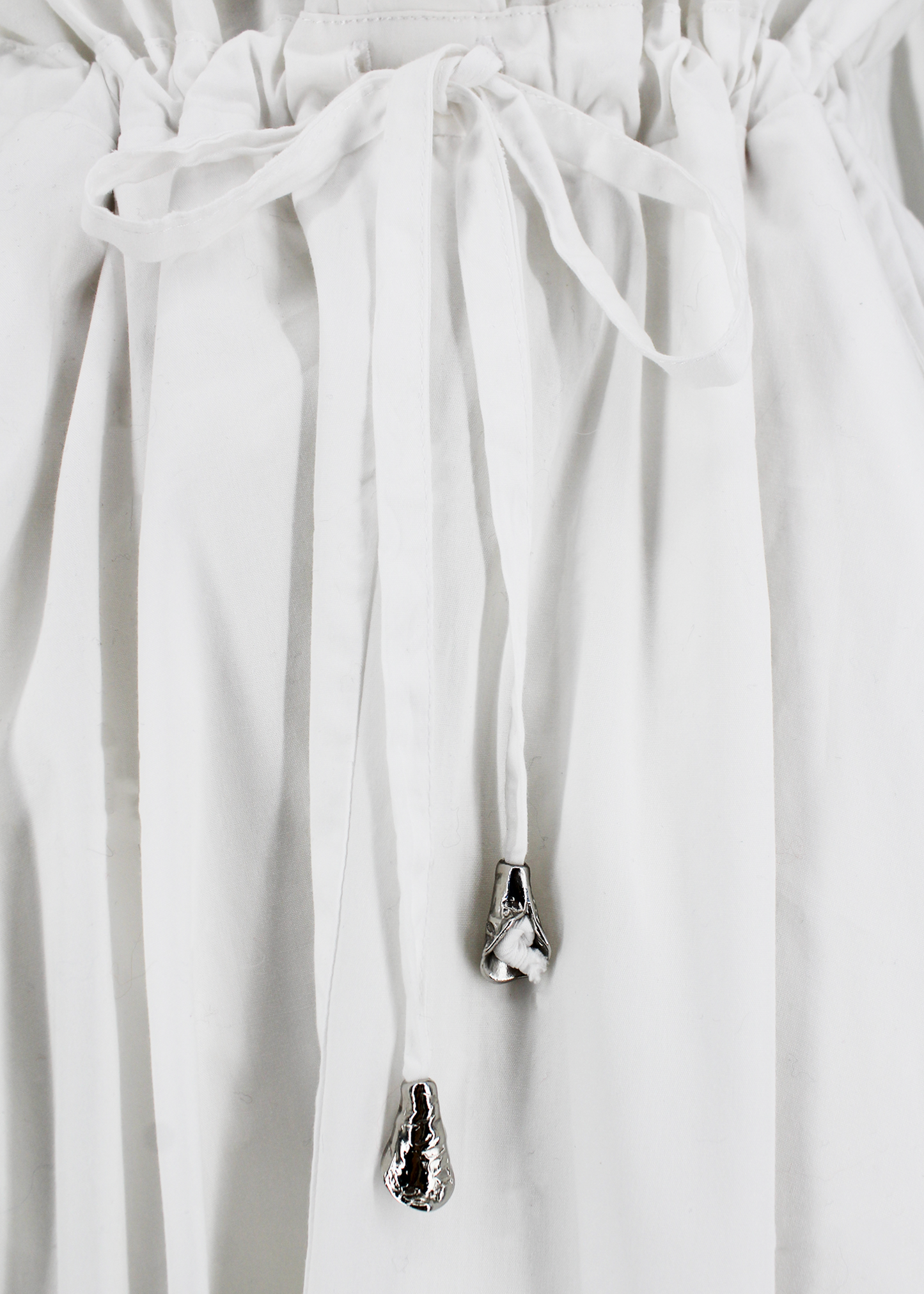 This is a white long sleeve button up t-shirt dress with a full skirt, adjustable tie waist, and Brest pocked detail.