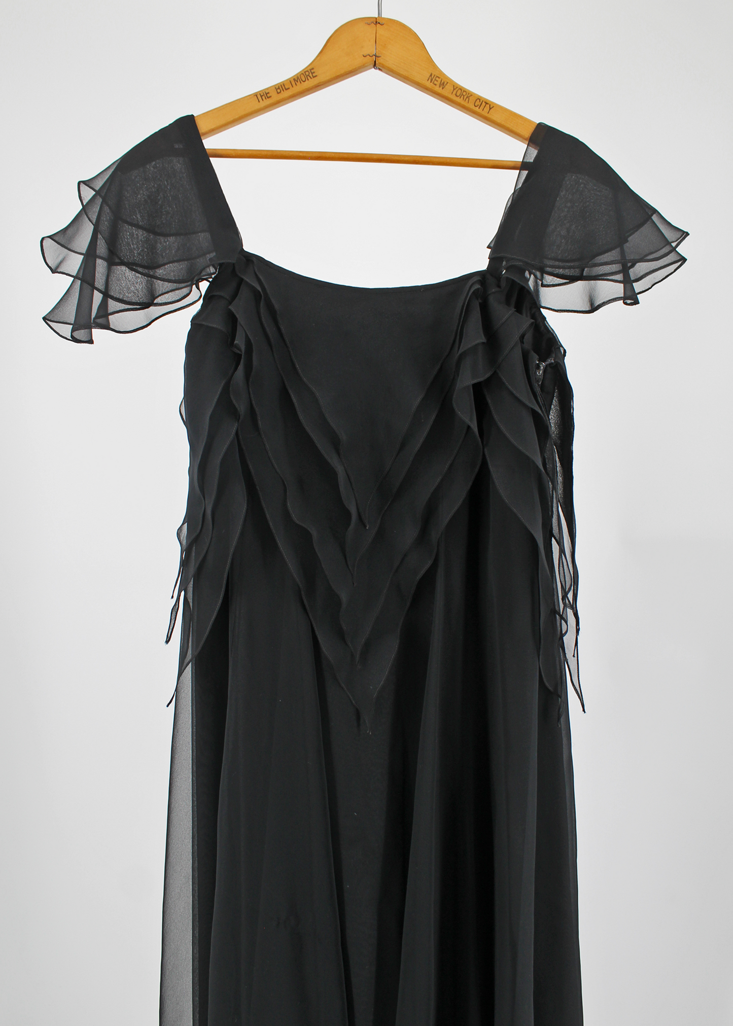 This is a Floor-length, black handkerchief tiered organza dress by London-based designer Jean Varon. The dress features Many, many layers of lightweight black organza are layered and draped to create a waterfall effect that flows as you walk.