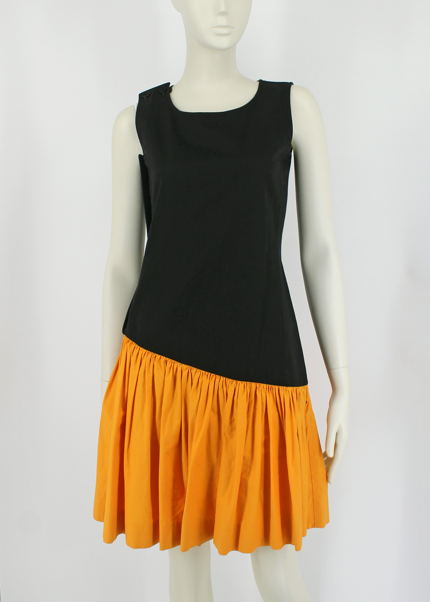 1980s incredible black YSL knee-length dress featuring a full, color-blocked, slanted marigold yellow cotton ruffled hem starting at the hip and ending above the knee. Buttons up on one side.